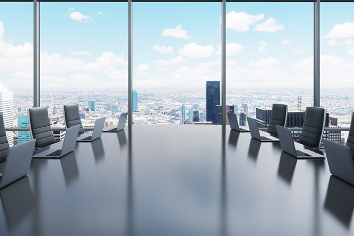 Empty executive board room overlooking city.