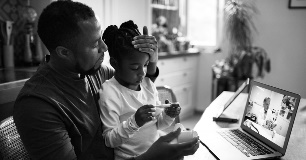 Father and Sick Child Virtual Visit with Doctor on Laptop