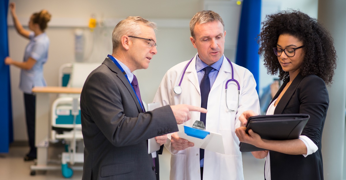 Doctor discussing paperwork with hospital administrators