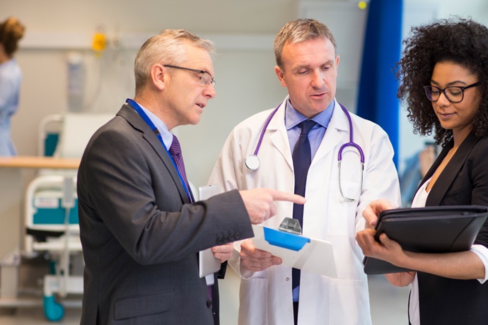 Doctor discussing paperwork with hospital administrators