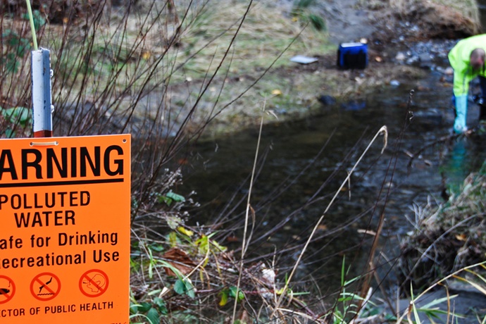 Scientist tests water from polluted creek