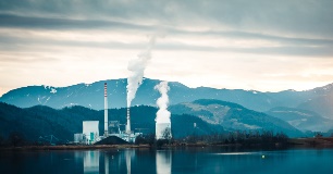 Factory with Smoke Stack on Edge of Lake