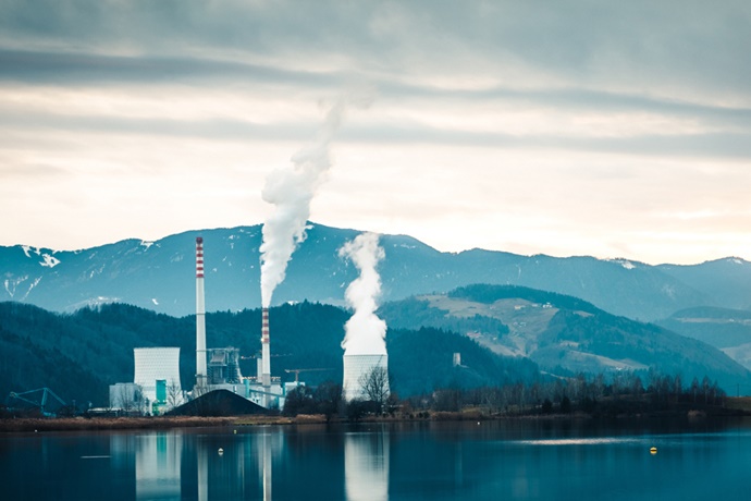 Factory with Smoke Stack on Edge of Lake