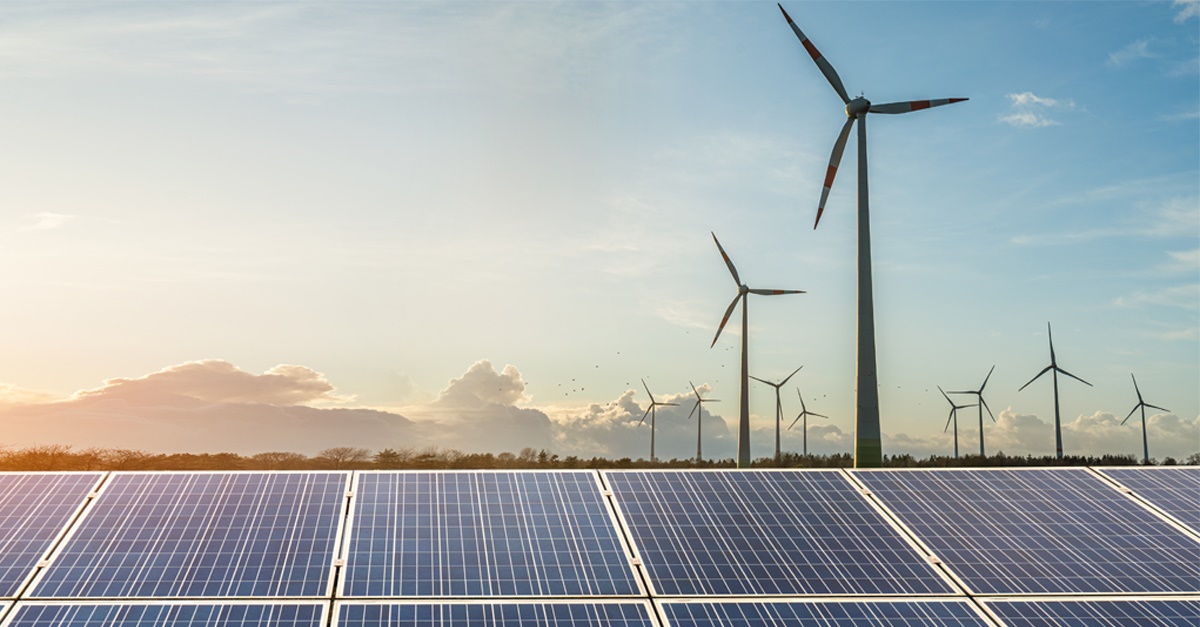Wind turbines and solar panels in deserted landscape.