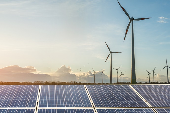 Wind turbines and solar panels in deserted landscape.