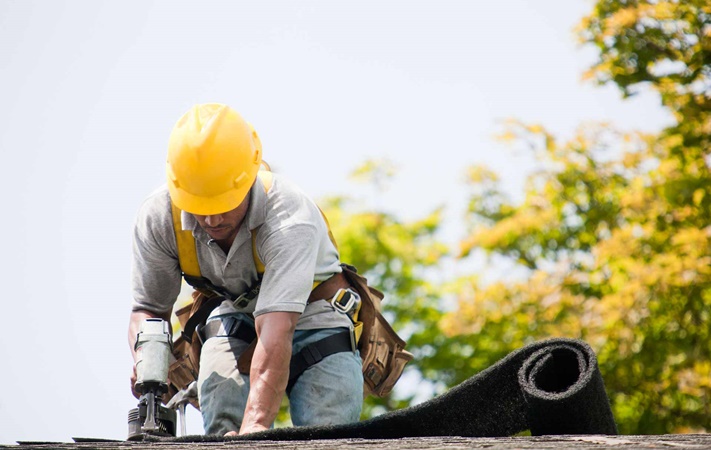 Roofing contractor working on roof