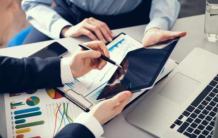 Two people holding iPad at desk